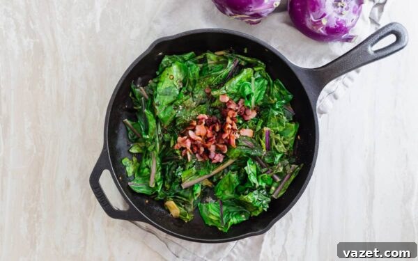 Bacon topped cooked kohlrabi greens with garlic and scallions.