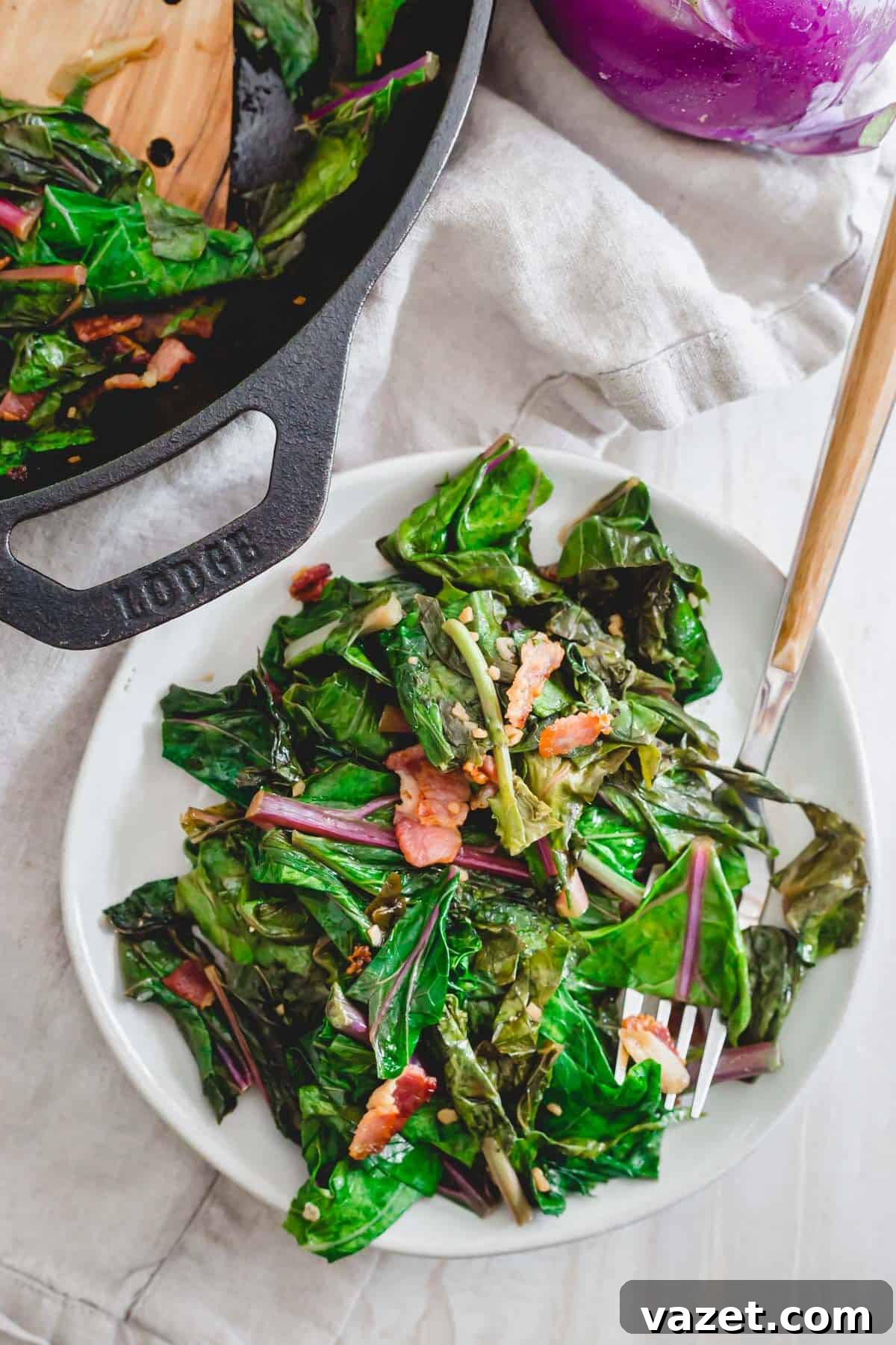 Cooked kohlrabi greens side dish with bacon, scallions and garlic. A delicious side dish of cooked kohlrabi greens, garnished with crispy bacon, sliced scallions, and minced garlic.