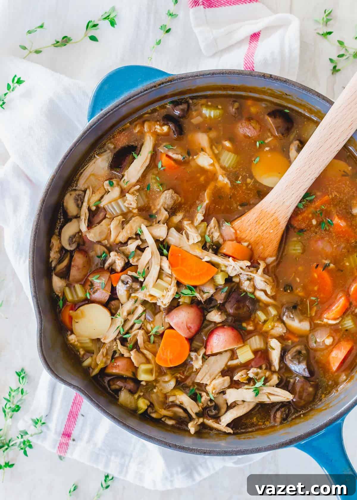 Turkey stew in a cast iron Dutch oven with wooden spatula. Hearty Turkey Stew cooking in a cast iron Dutch oven with a wooden spatula.