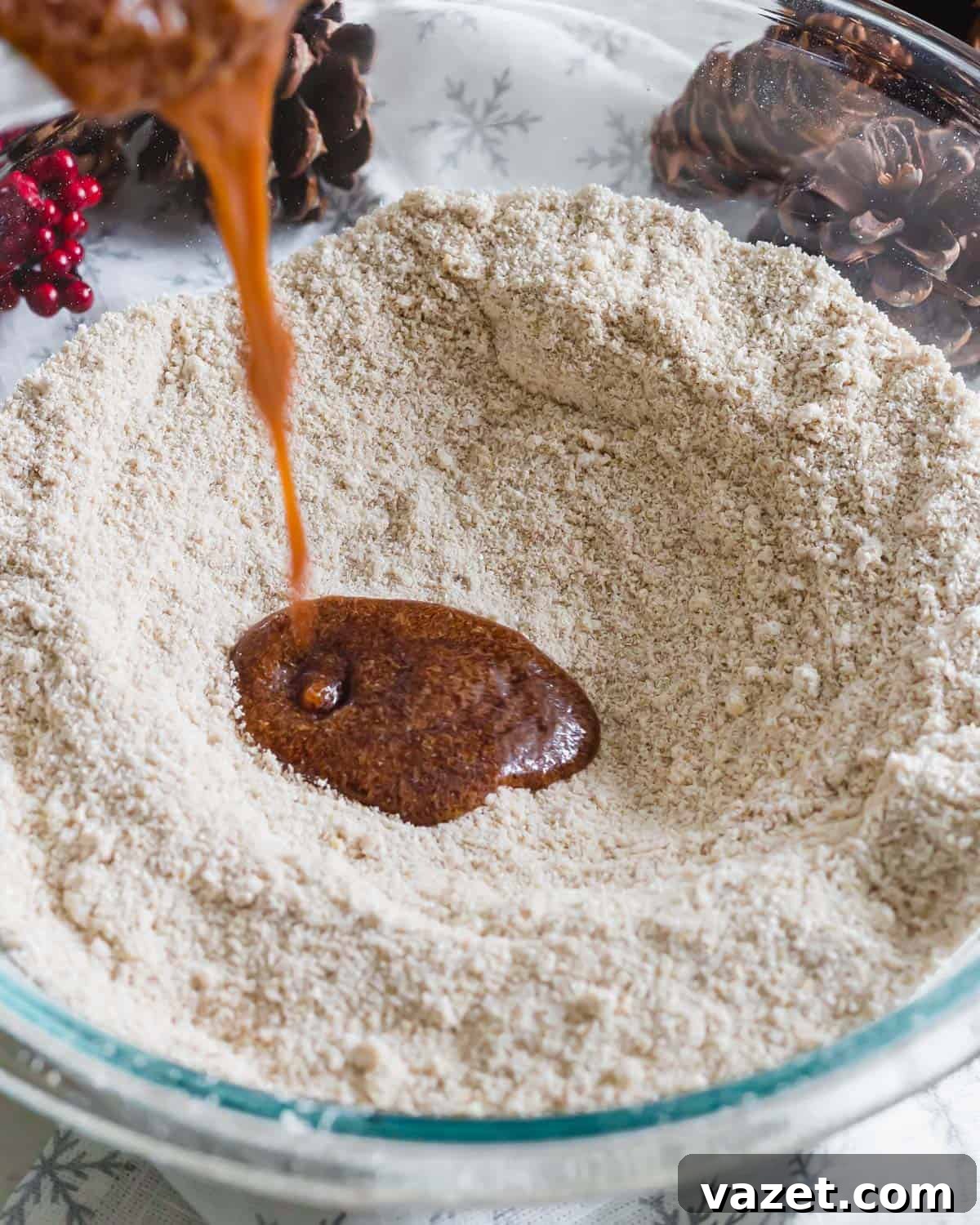 A bowl filled with a mix of oat flour and almond flour, alongside a small glass of dark molasses, key ingredients for gingerbread waffles.