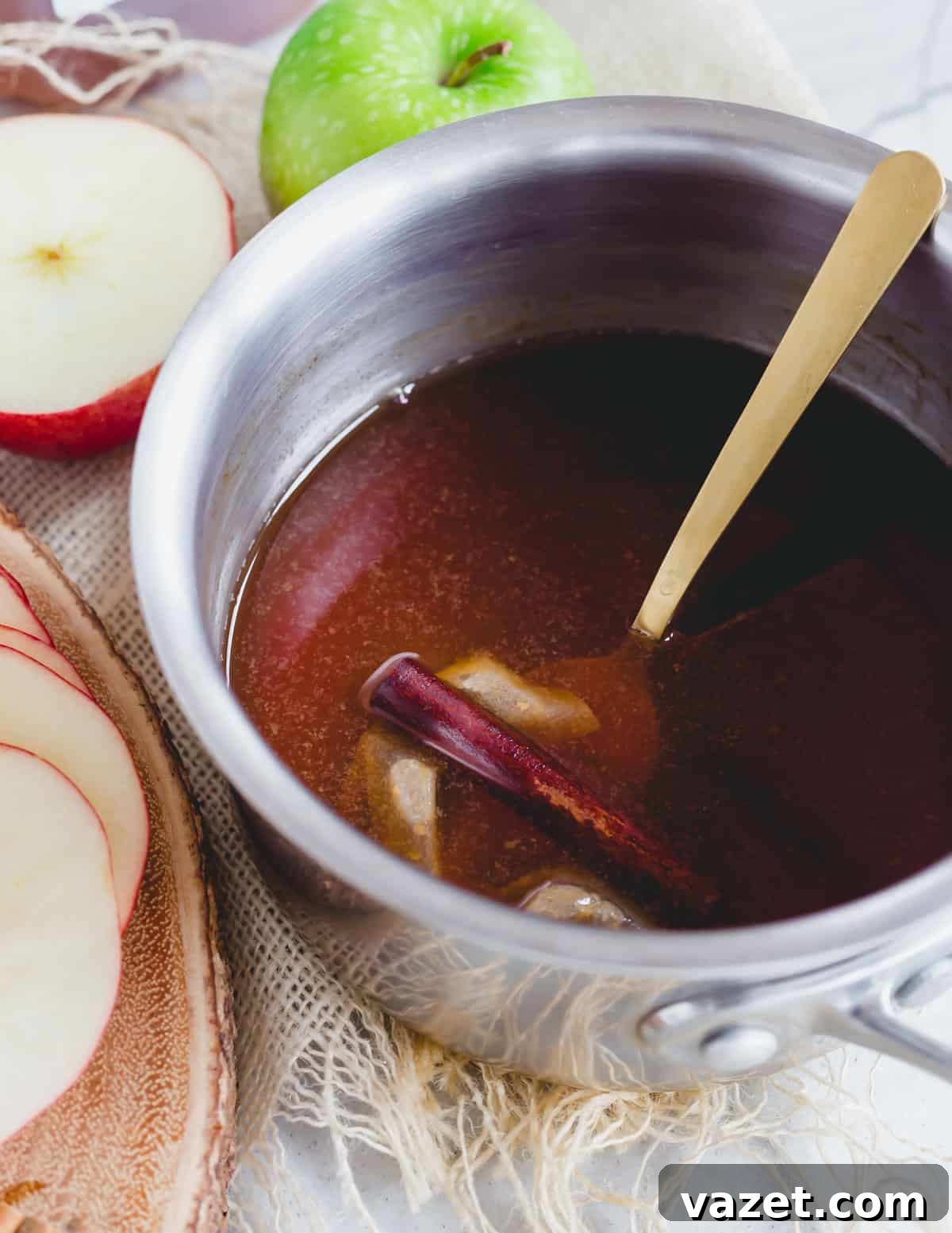 The Simple Art of Brewing Apple Cider Tea Black tea bags simmering with apple cider in a metal pot with a cinnamon stick, creating a rich aroma.