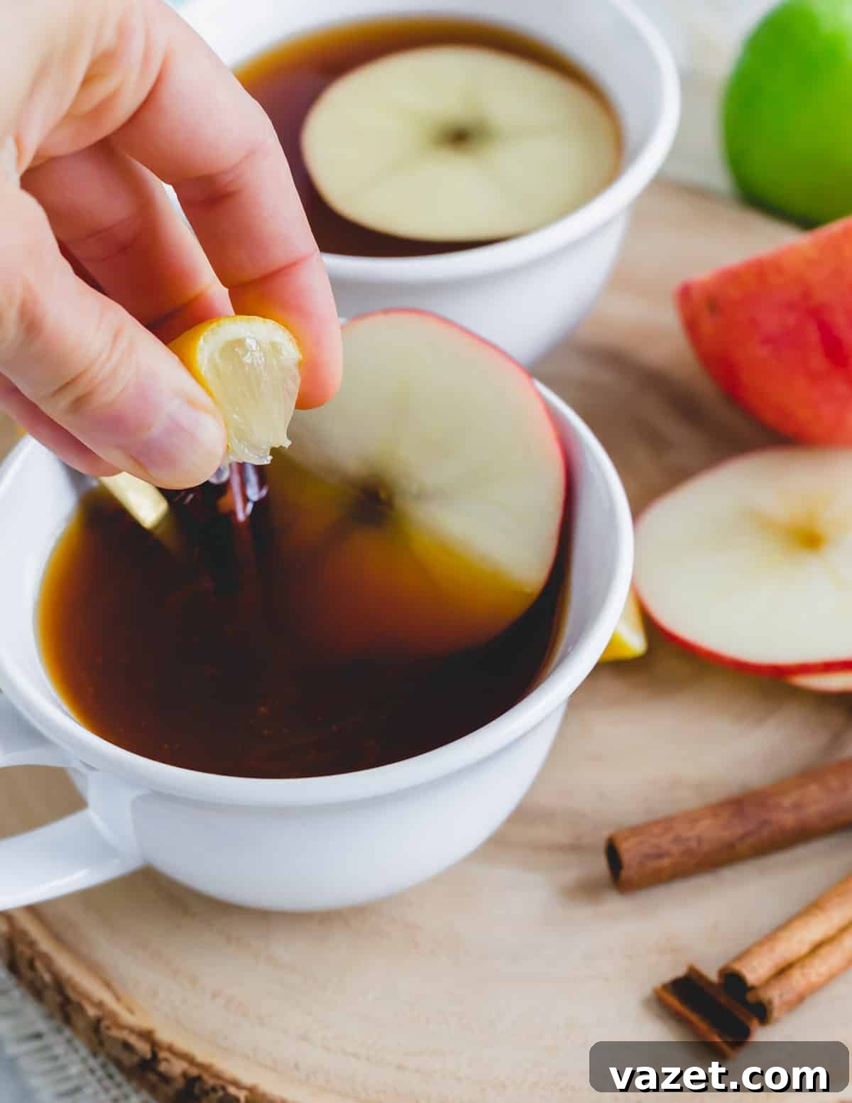 The Bright Finish: A Squeeze of Lemon Squeezing a lemon wedge into apple cider tea in a white mug, adding a bright, zesty touch.