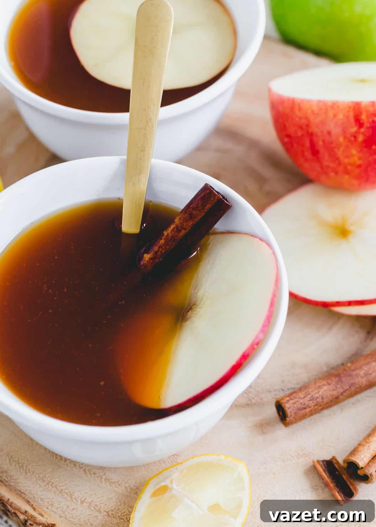 The Essence of Autumn in a Cup Warm apple cider tea with cinnamon garnished with an apple slice in a mug, embodying fall comfort.