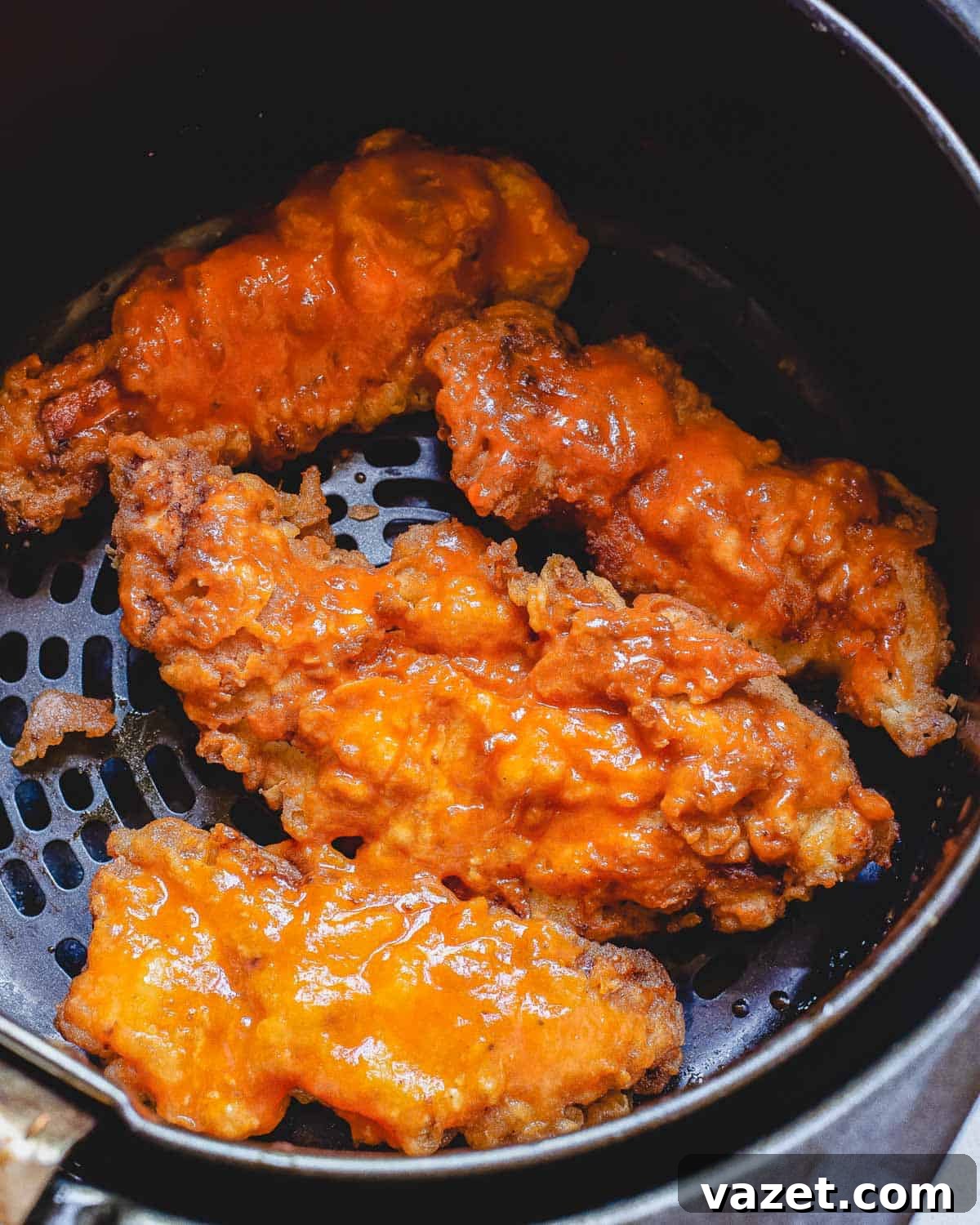Crispy Air Fried Buffalo Chicken Strips Ready to Serve A close-up of crispy air fried buffalo chicken strips, showcasing their texture and coating, arranged in the air fryer basket.