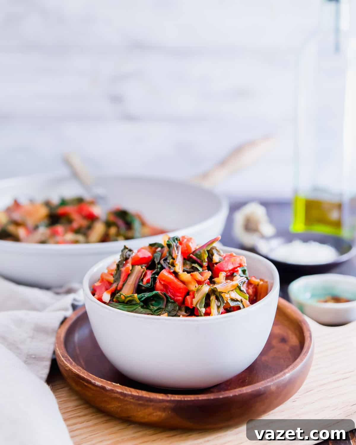Quick Sauteed Swiss Chard 5 A simple yet elegant serving of sautéed Swiss chard with tomatoes, onions, and garlic, garnished with a generous sprinkle of fresh Parmesan cheese.