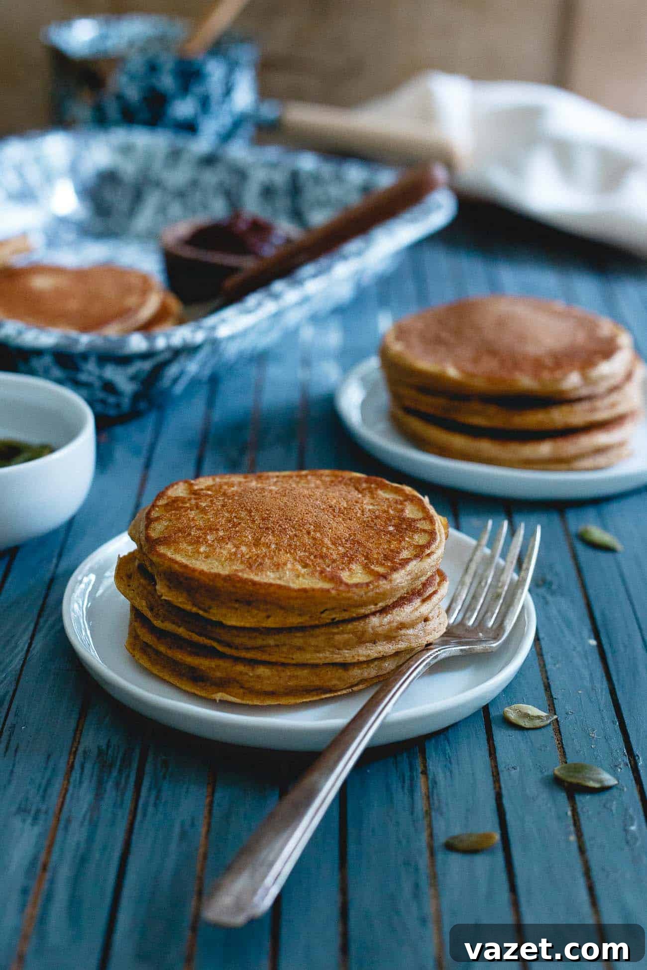 Delicious pumpkin protein pancakes topped with whipped cream and a sprinkle of cinnamon, showcasing a healthy and filling breakfast.