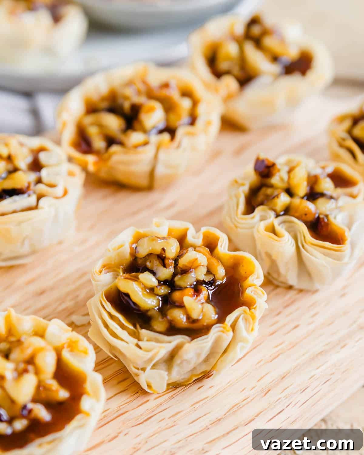Bite-Sized Pumpkin Delights 2 Golden pumpkin pie bites arranged neatly on a rustic wooden cutting board, ready to be enjoyed.