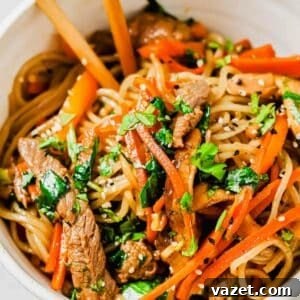 A bowl of sweet potato glass noodles with beef and vegetables.