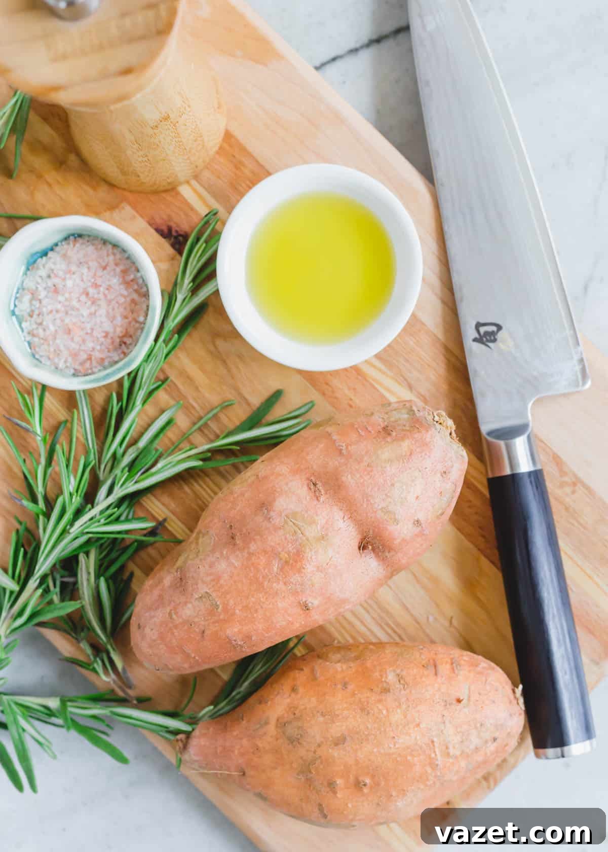 Sweet potatoes, olive oil, salt, pepper and rosemary on a cutting board with a knife. Sweet potatoes, olive oil, salt, pepper and rosemary on a cutting board with a knife.