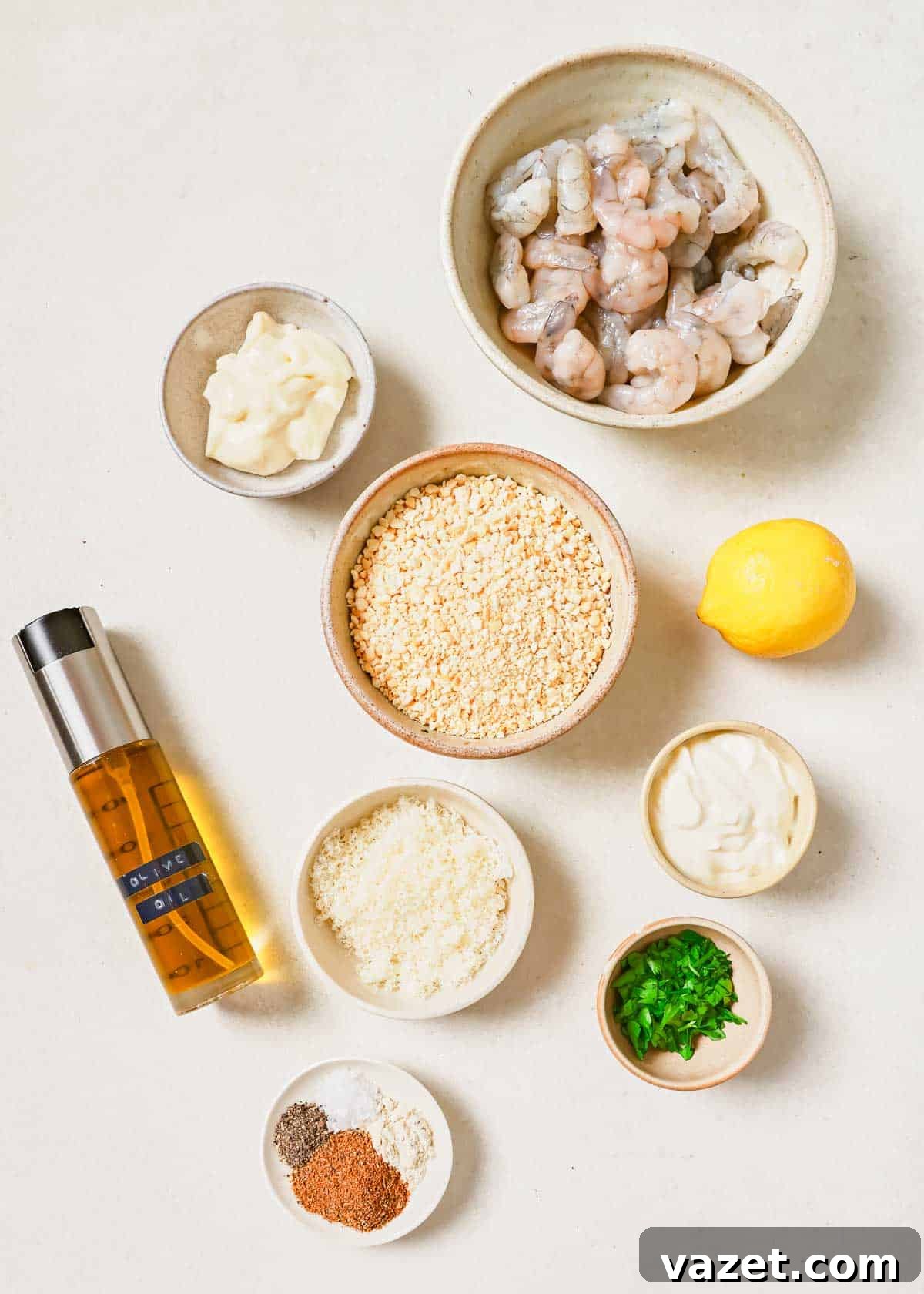 Quick Baked Shrimp Poppers 3 Various ingredients for popcorn shrimp, including fresh shrimp, mayonnaise, seasoning, and breadcrumbs, arranged on a white surface.