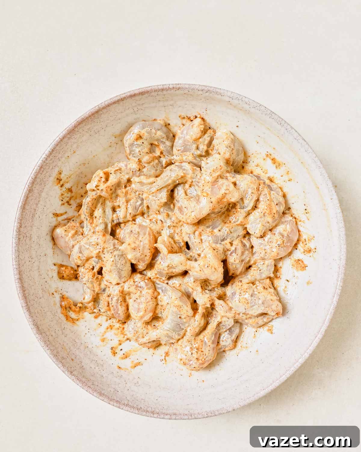 Quick Baked Shrimp Poppers 6 A bowl of shrimp thoroughly coated in a creamy mayonnaise and spice mixture, ready for breading.