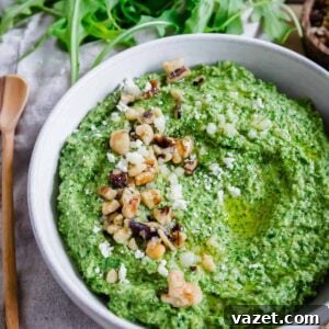 Close up of a bowl of pesto made with arugula with walnuts and grated parmesan.