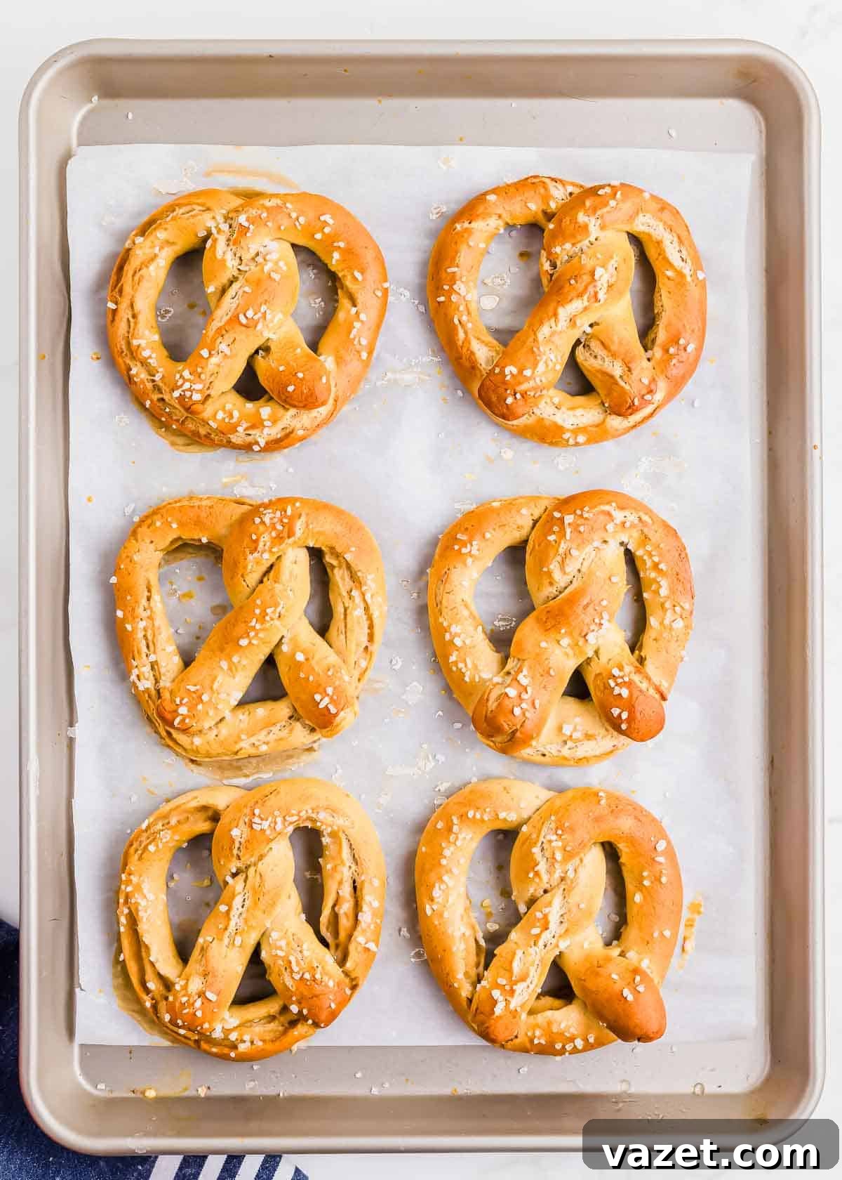 Cloud-Soft Gluten-Free Pretzels 11 A baking sheet with six freshly baked soft gluten-free pretzels topped with coarse salt.