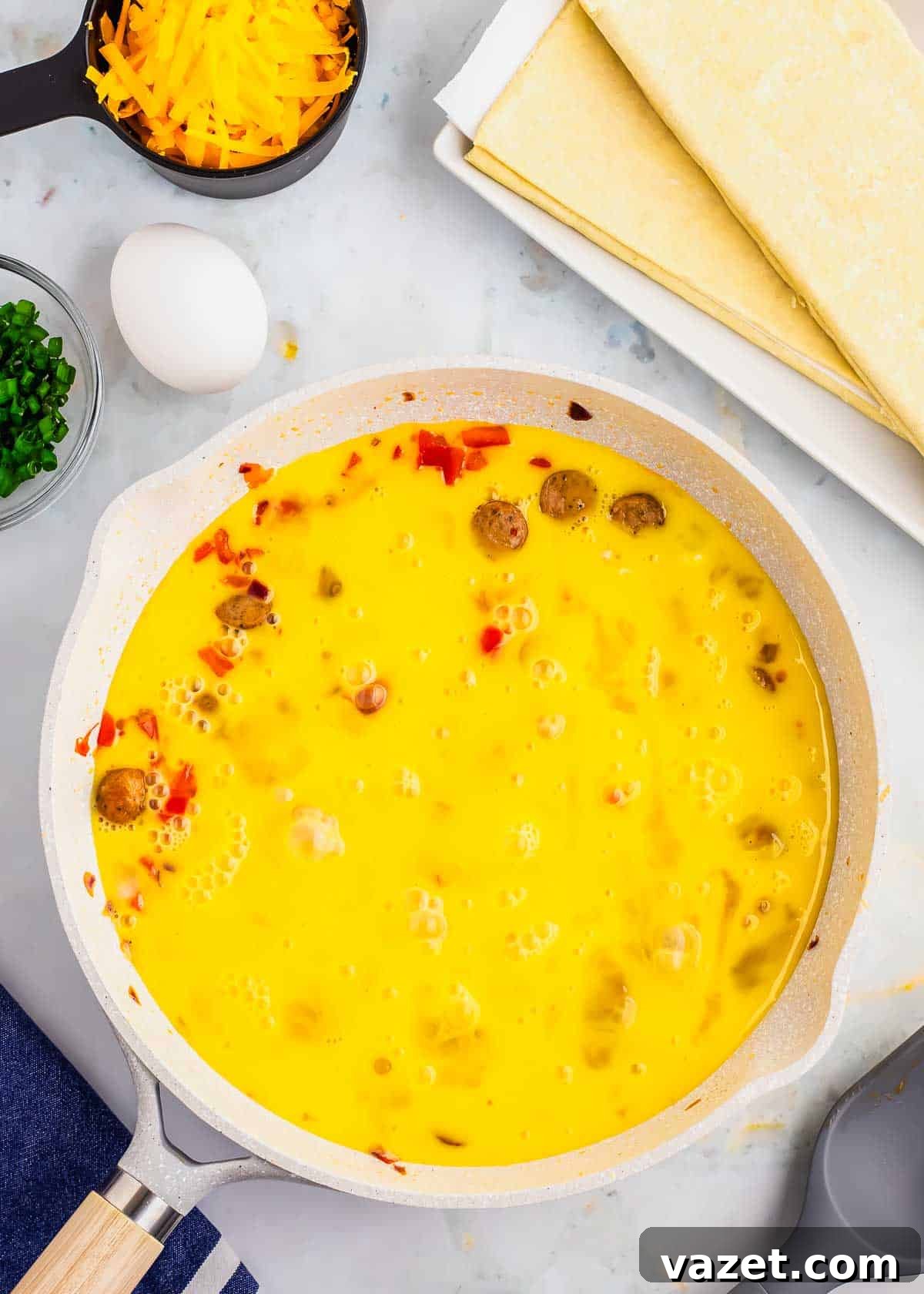 Artisan Stuffed Pockets 5 A skillet full of eggs, cheese, and other ingredients.