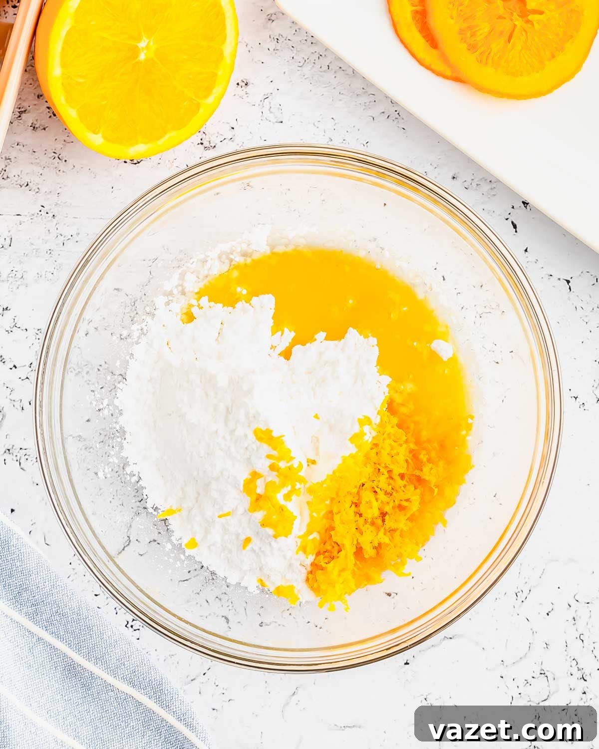 Zesty Orange Muffins 5 Preparing the vibrant orange glaze for muffins in a clear glass bowl, showcasing its smooth texture.