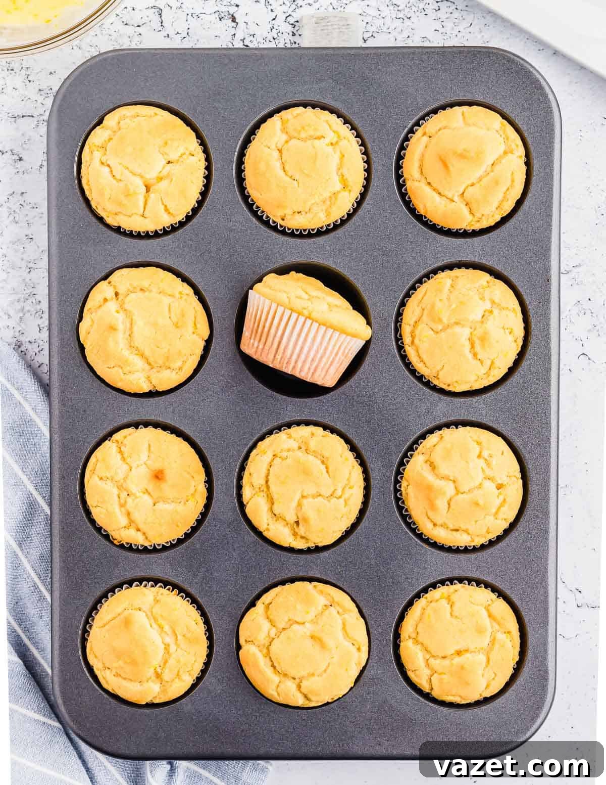 Zesty Orange Muffins 6 Freshly baked orange muffins perfectly risen in a muffin tin, still warm from the oven.