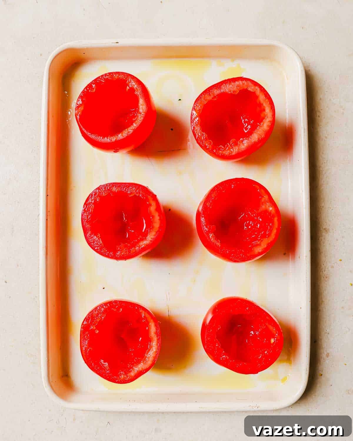 Home Freezing Tomatoes Made Simple 4 Six hollowed-out ripe tomatoes are placed in two rows on a rectangular white tray.
