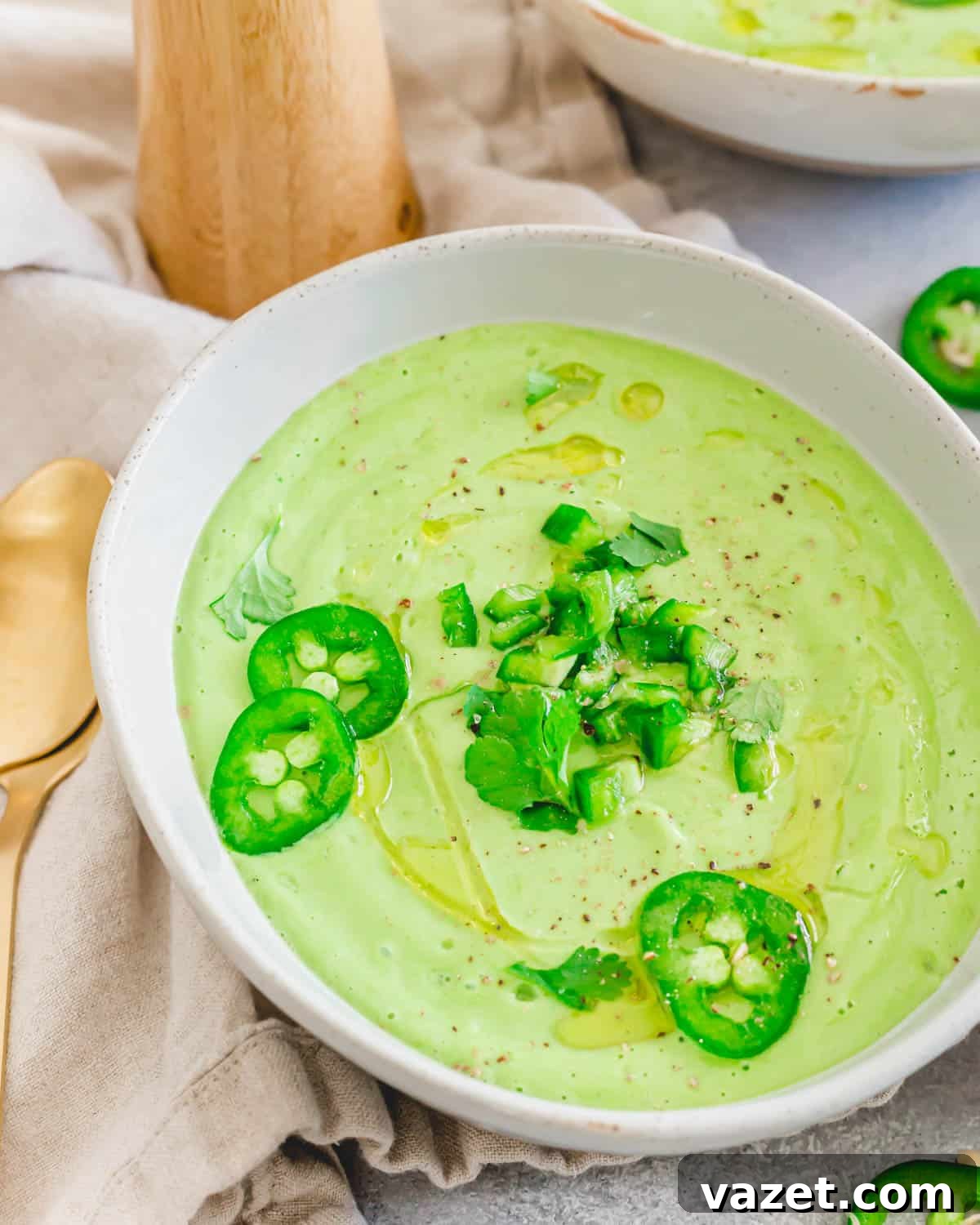 Avocado gazpacho made in the blender in a bowl with spoons on the side. Avocado gazpacho made in the blender in a bowl with spoons on the side.