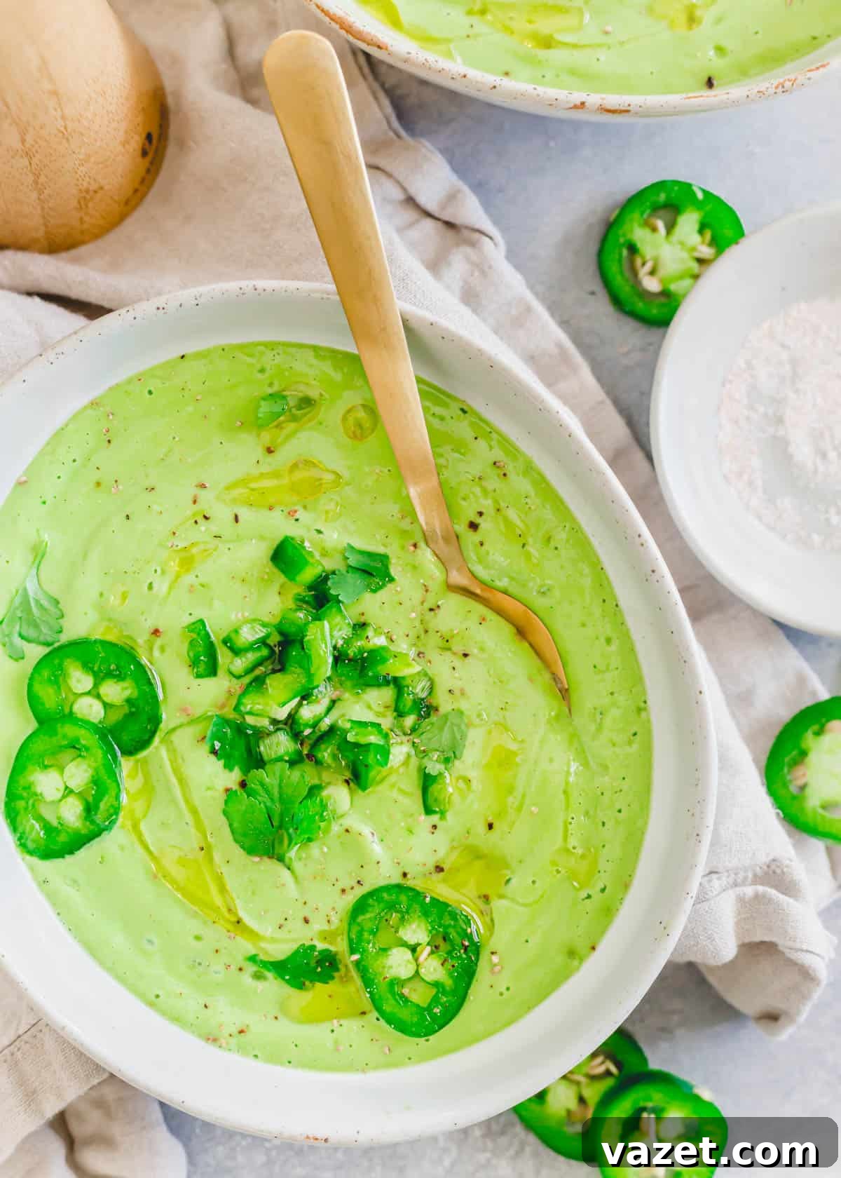 Cold creamy avocado soup in a bowl with a spoon. Cold creamy avocado soup in a bowl with a spoon.