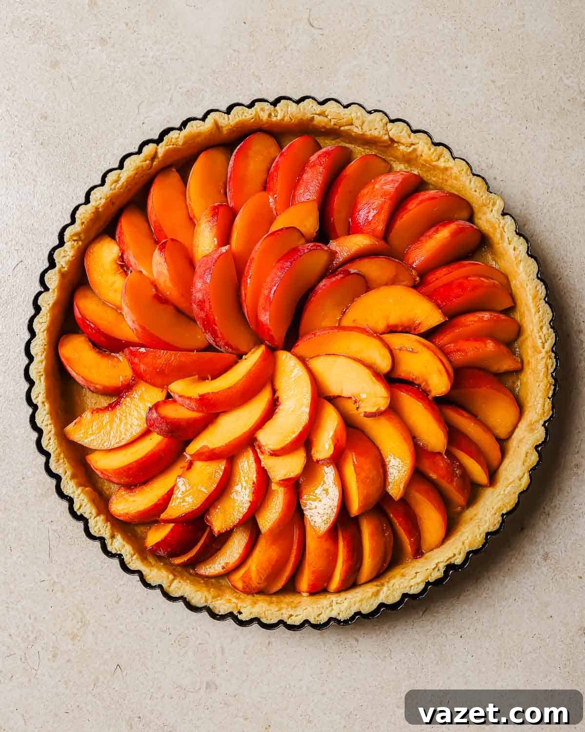 Decoding Peaches: Your Sweet Dive into Varieties 3 Tart crust with sliced peaches arranged in a circular pattern inside it.