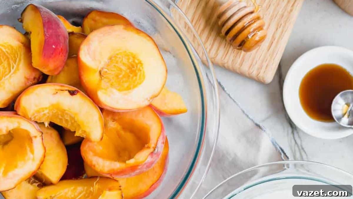 Decoding Peaches: Your Sweet Dive into Varieties 5 Sliced peaches in a glass bowl with a honey dipper and a small dish of honey on the side.