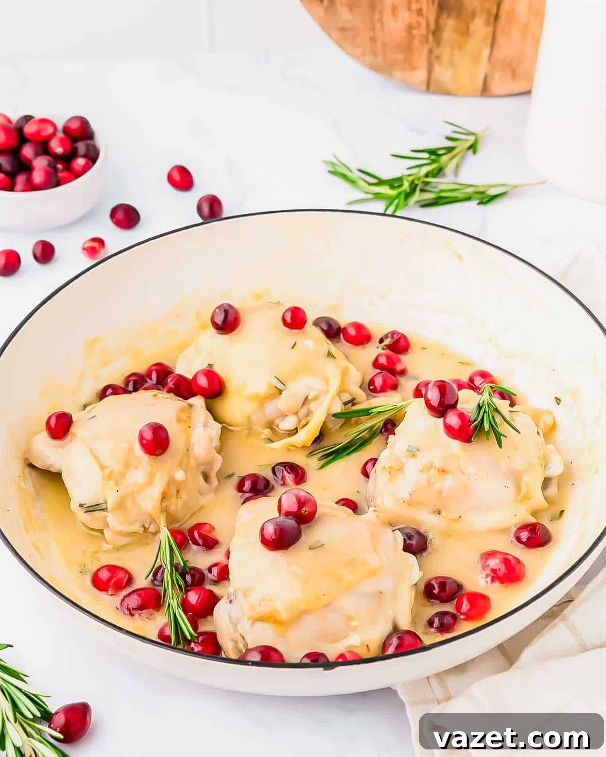 Cranberry Chicken Delight 2 Creamy cranberry chicken thighs garnished with rosemary and cranberries.