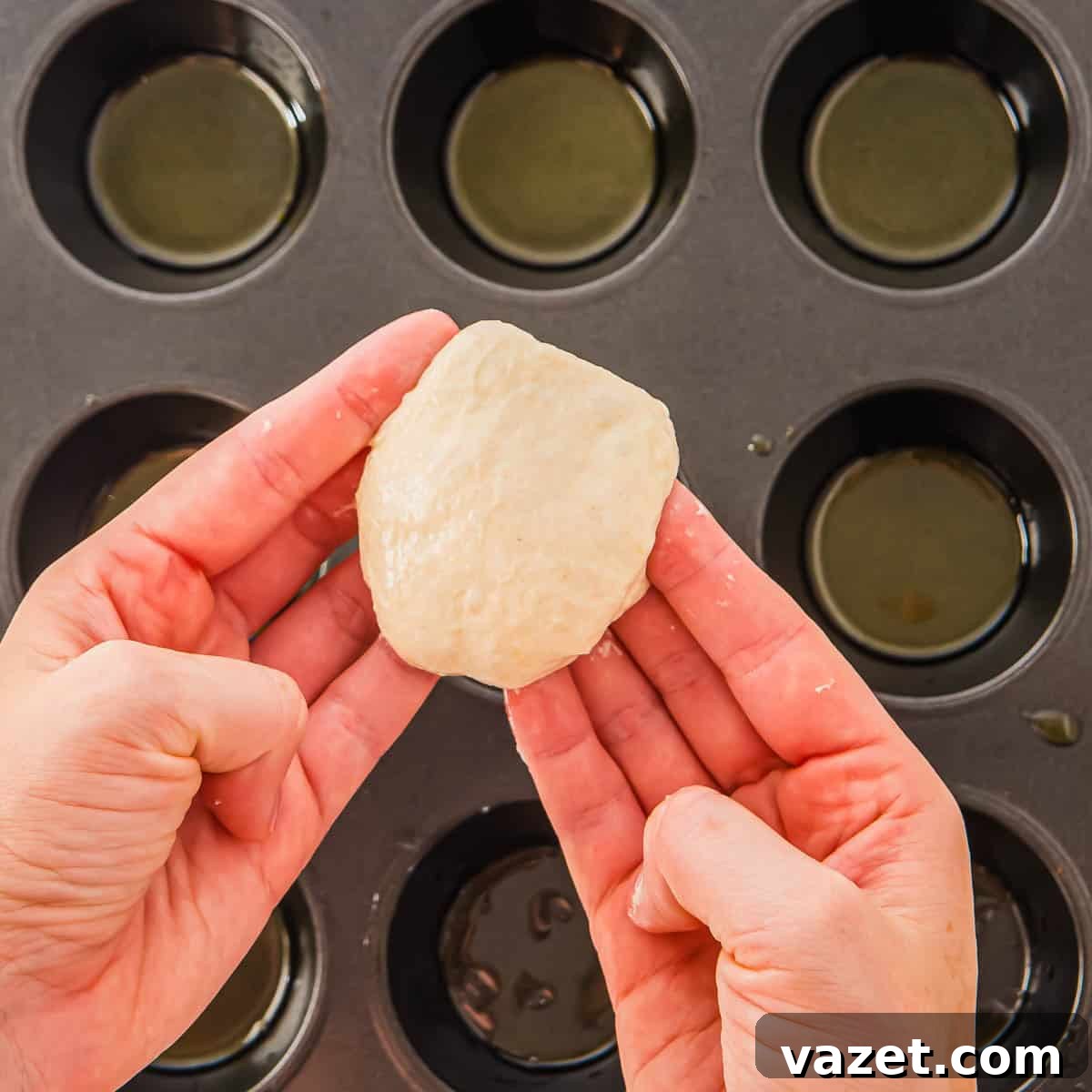 Portioning focaccia dough into a muffin tin.