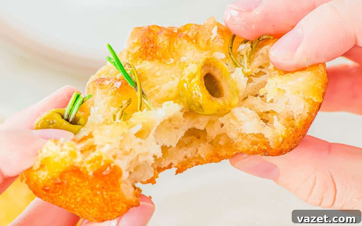 Pulling apart a focaccia muffin to show its soft texture.