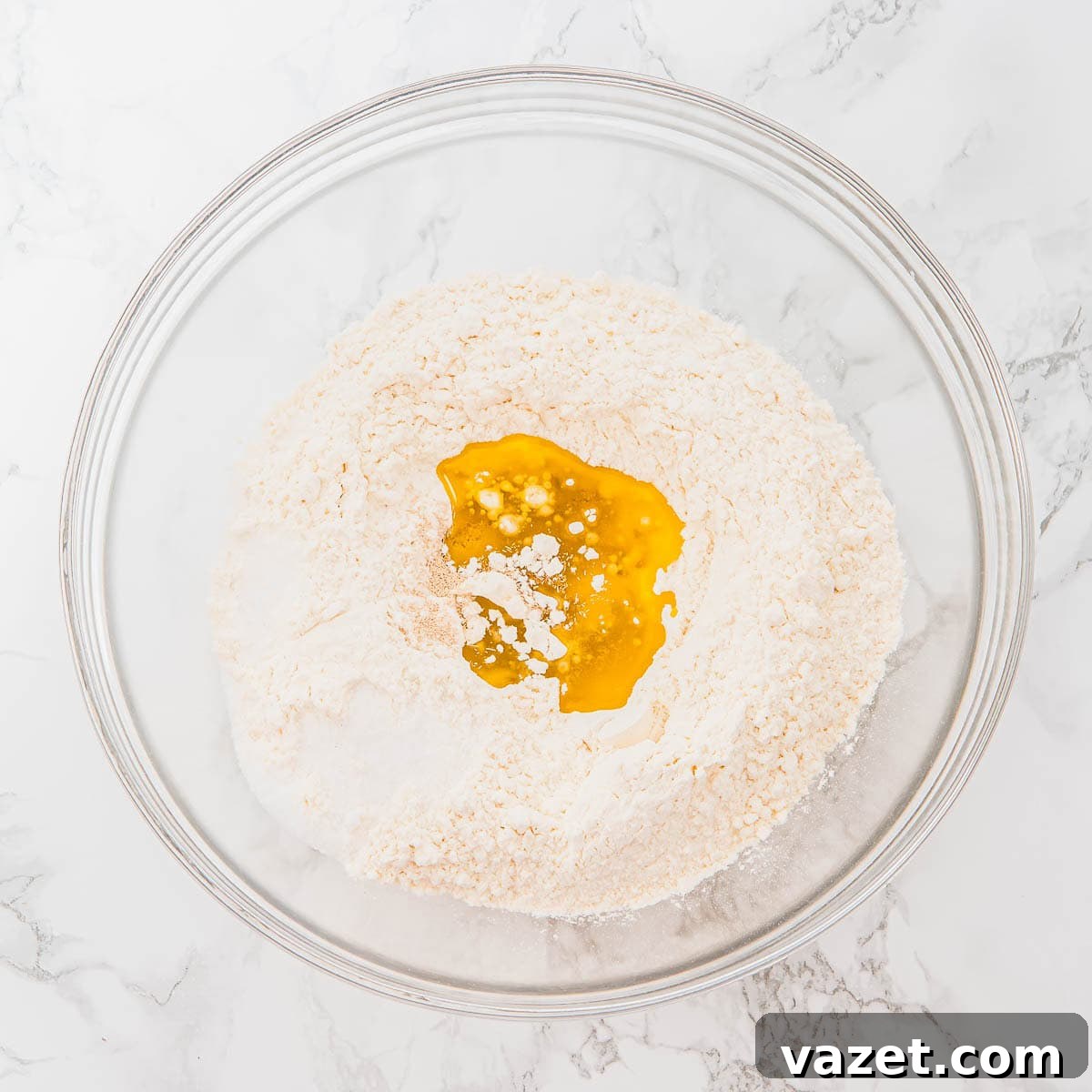 Flour and olive oil in a glass bowl.
