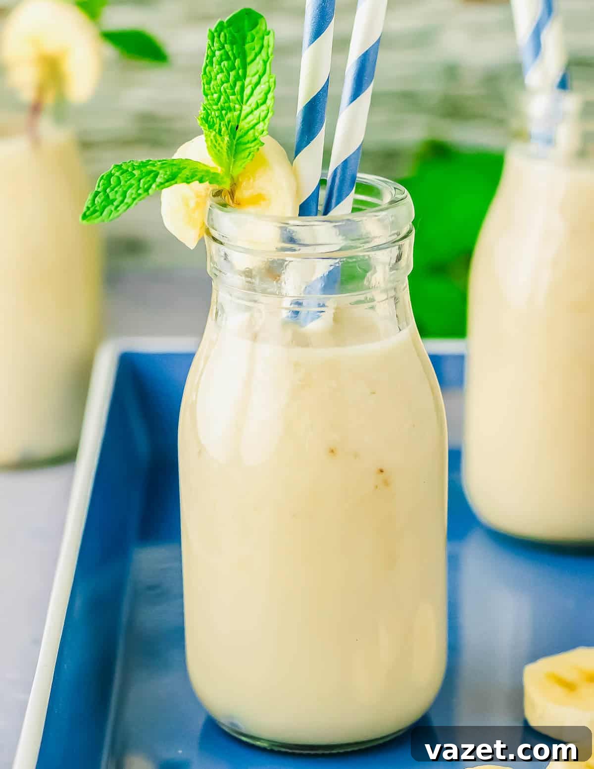 Korean Banana Bliss 3 A close-up of Korean banana milk in a glass bottle with striped straws.