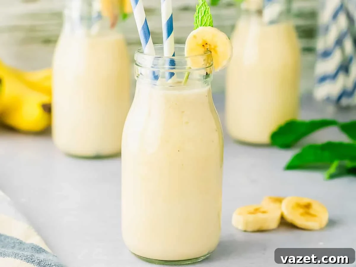Korean Banana Bliss 4 A bottle of creamy banana milk with two striped straws and banana slices.