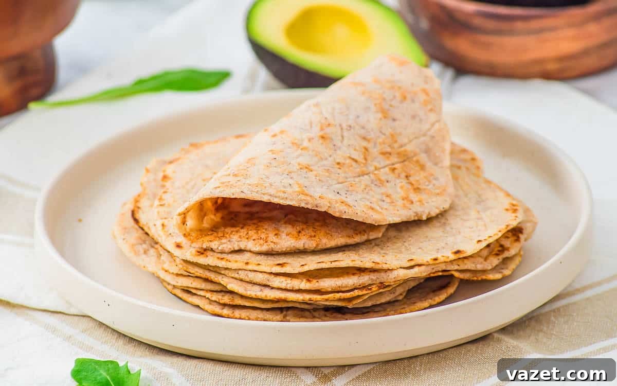 A stack of almond flour tortillas with avocado and greens.