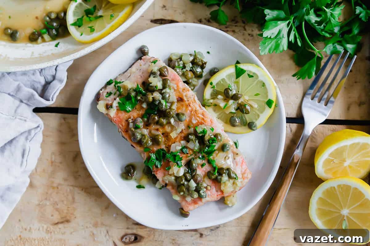 Lemon Butter Salmon Piccata with Capers and Parsley 9 Salmon piccata on a plate with a fork on the side.