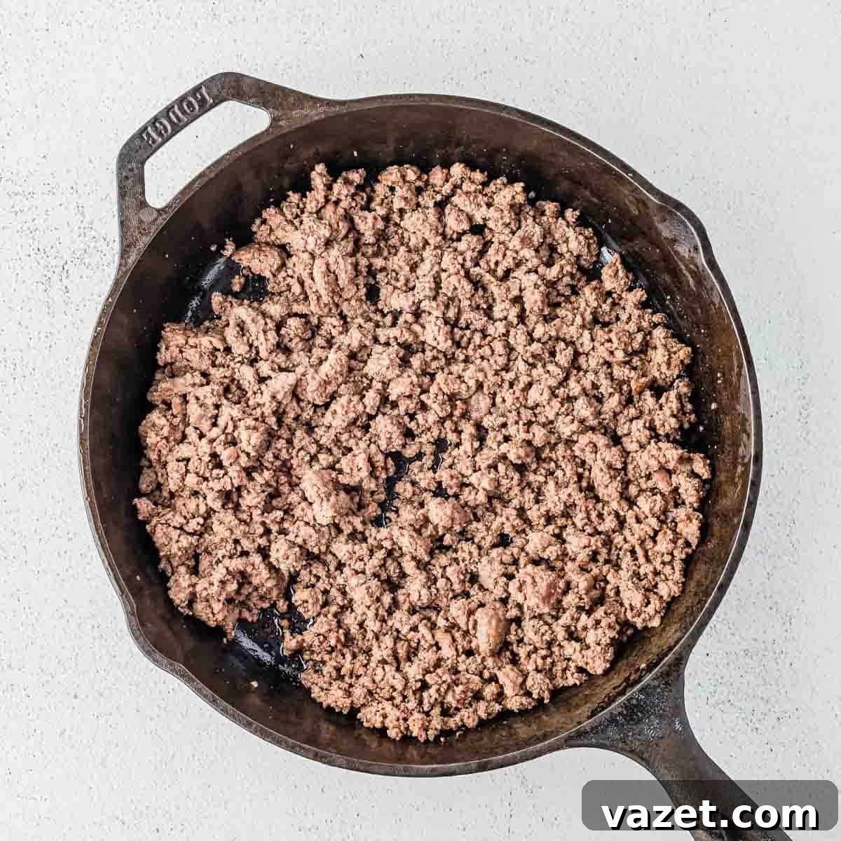 Big Mac Salad Recipe: Classic Cheeseburger Salad with Secret Sauce 8 Cooked ground beef in a black cast iron skillet, displayed on a light-colored surface.