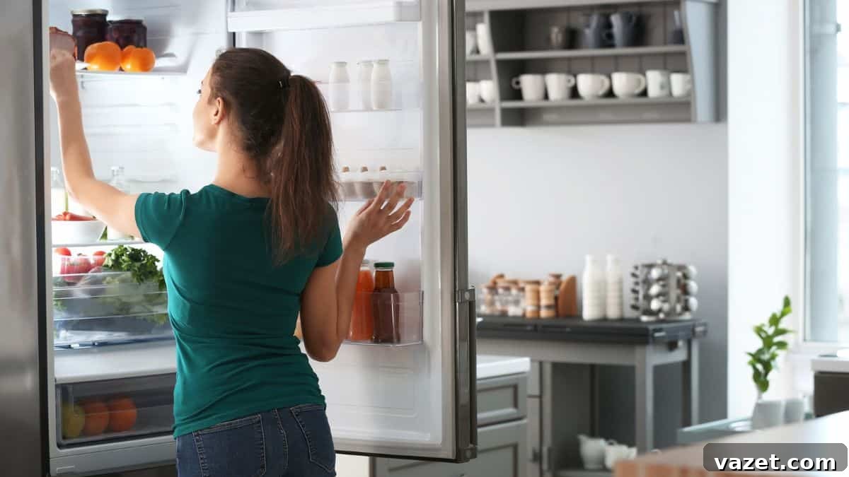 A woman opening the door of a refrigerator.